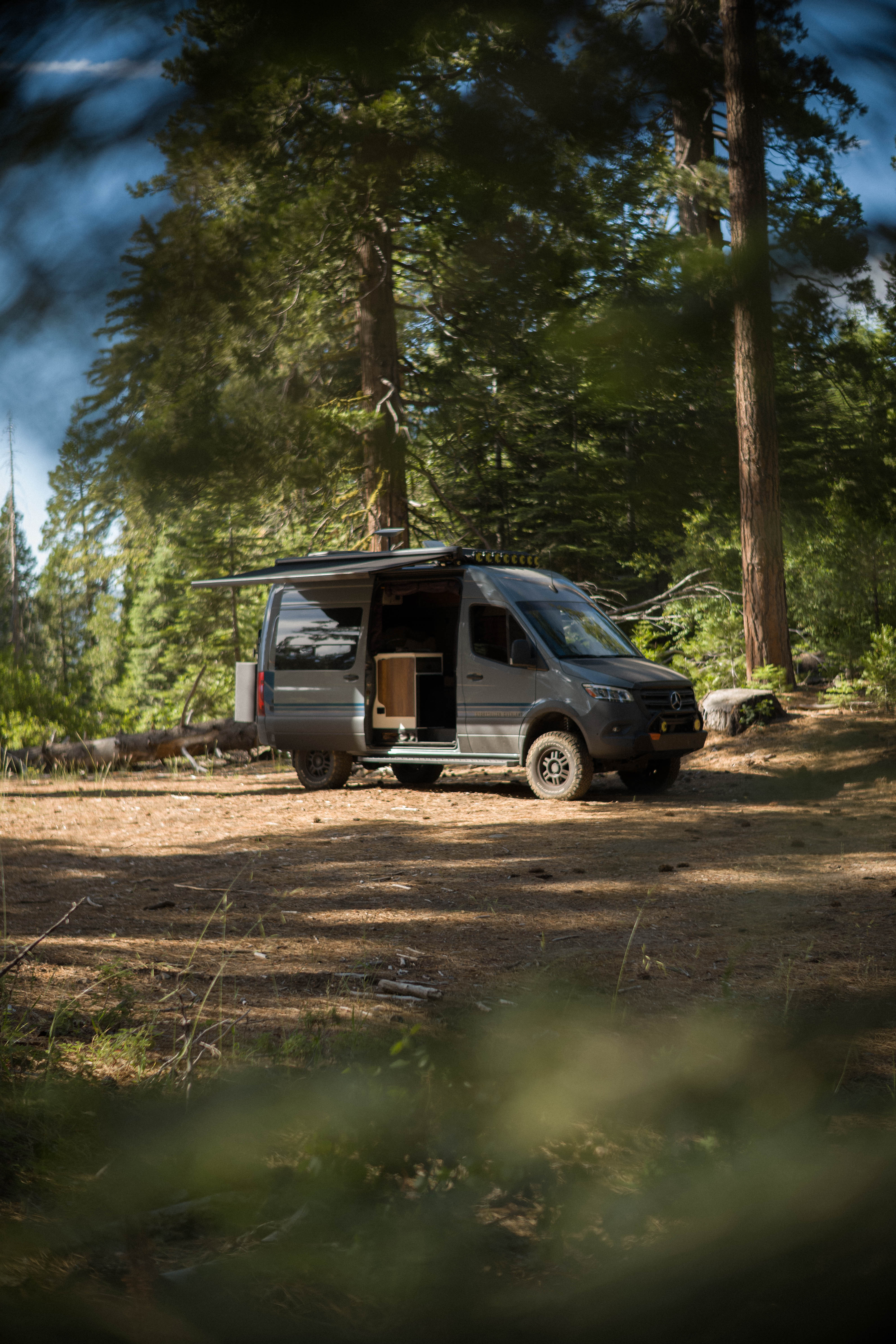 My Storyteller Overland van parked in a Sierra campsite with the awning out